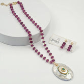 Jewelry set with purple beaded necklace and earrings on a white background