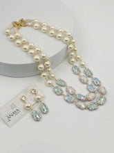Pearl necklace with gemstone accents and matching earrings on a white background, featuring the brand 'The Anaya Collections'.