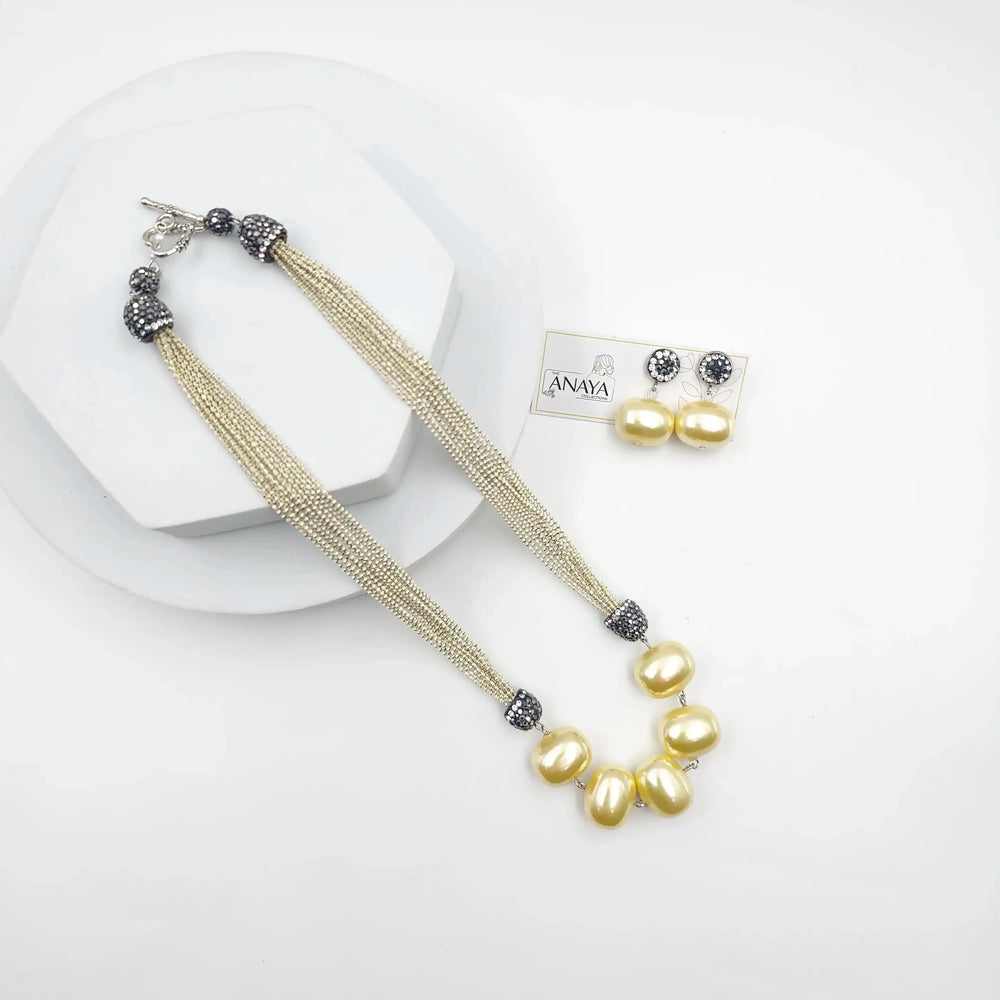 Pearl necklace and earrings set on a white background with ANAYA branding.