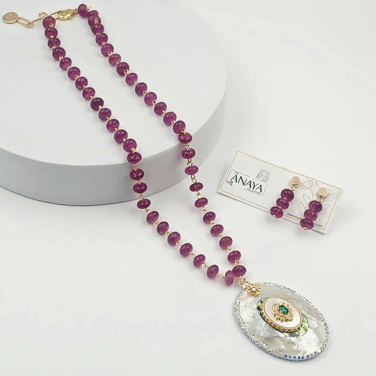Jewelry set with purple beaded necklace and earrings on a white background
