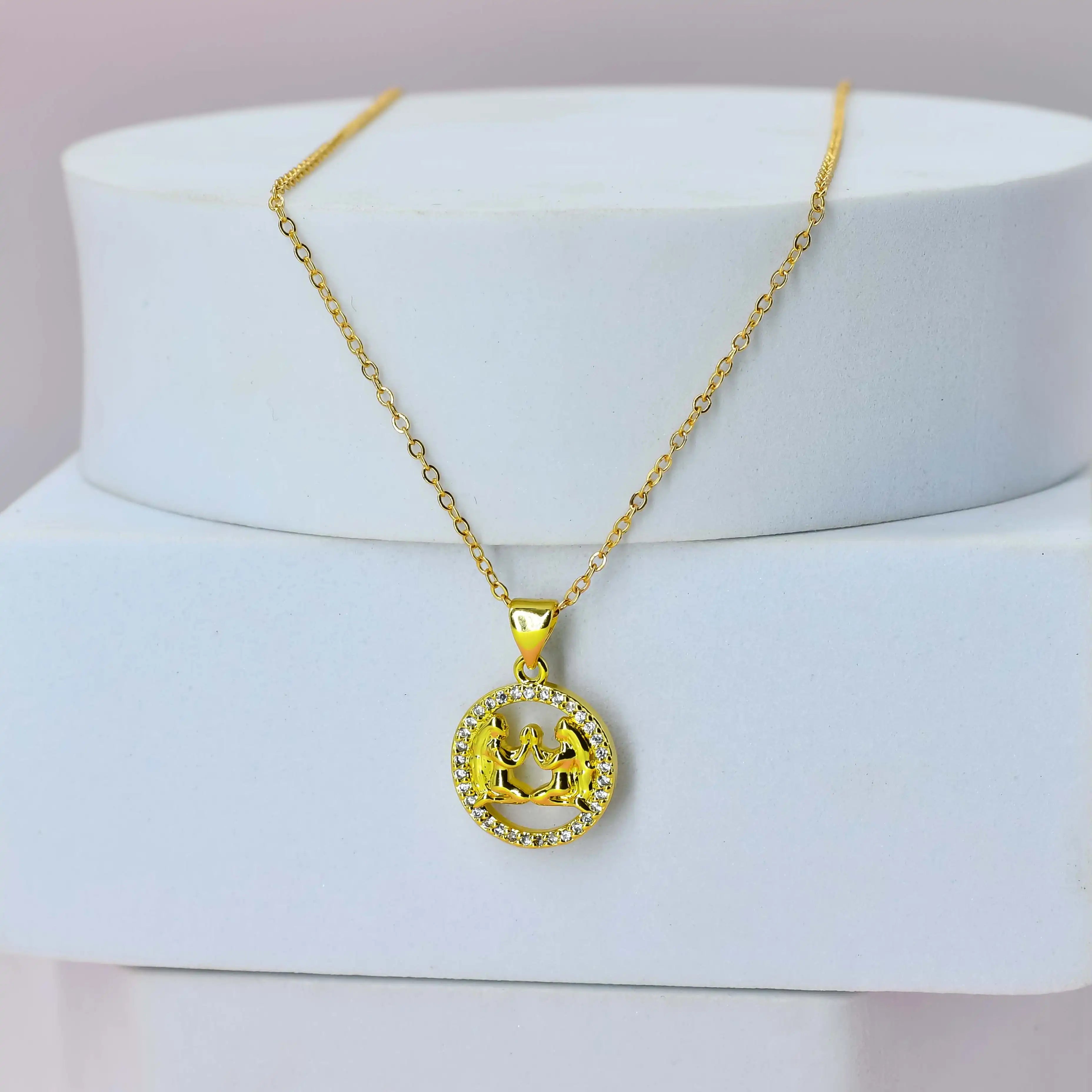 Gold Plated necklace with a Gemini pendant on a white stand