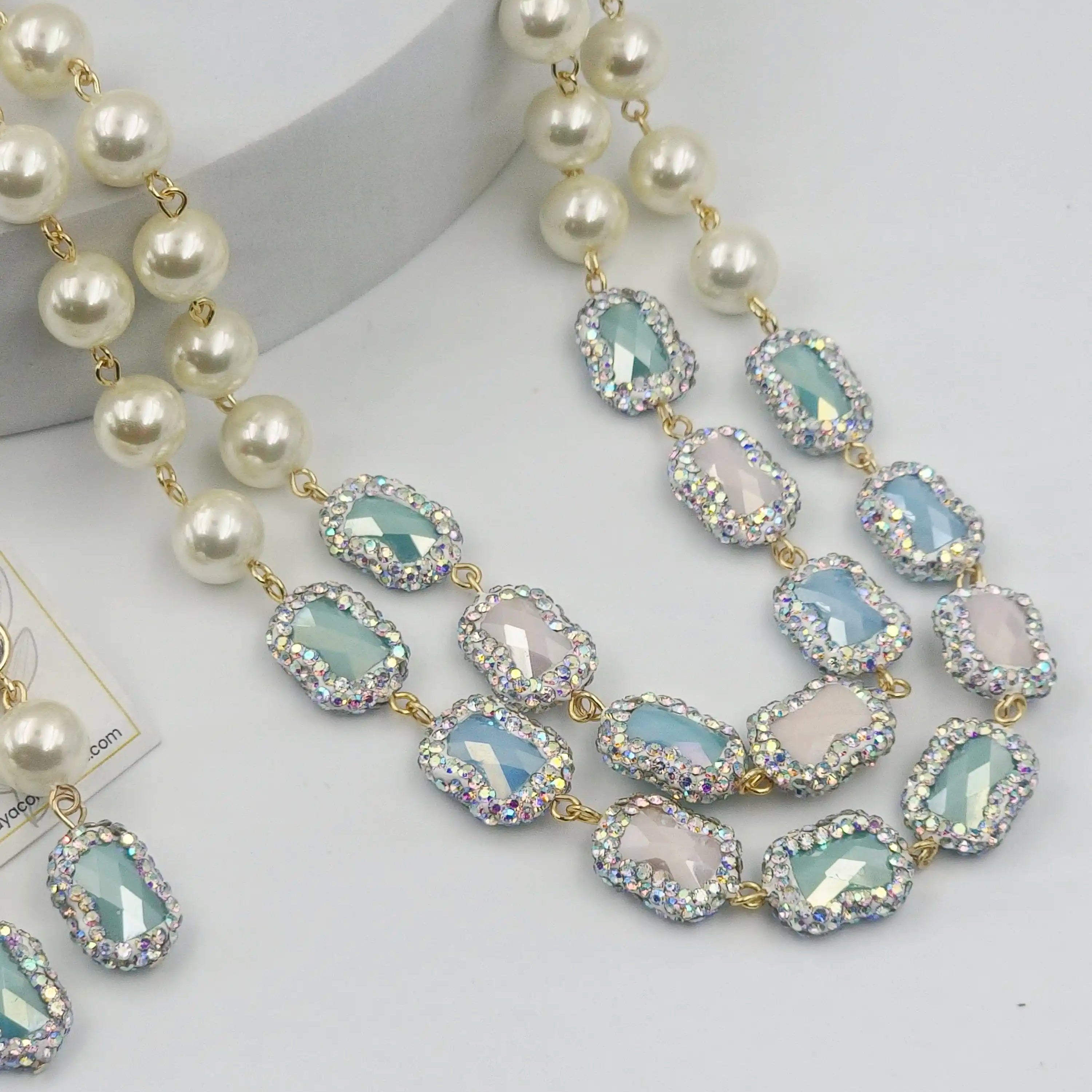 Necklace with pearls and light blue gemstones on a white background