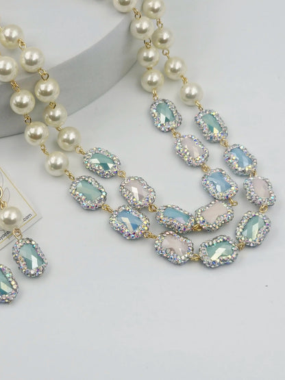 Necklace with pearls and light blue gemstones on a white background