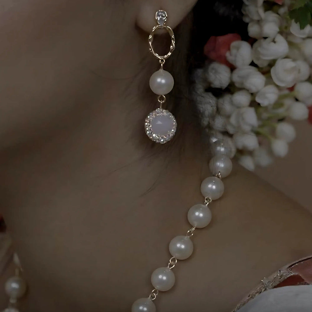 Close-up of an ear wearing a pearl earring with a blurred background