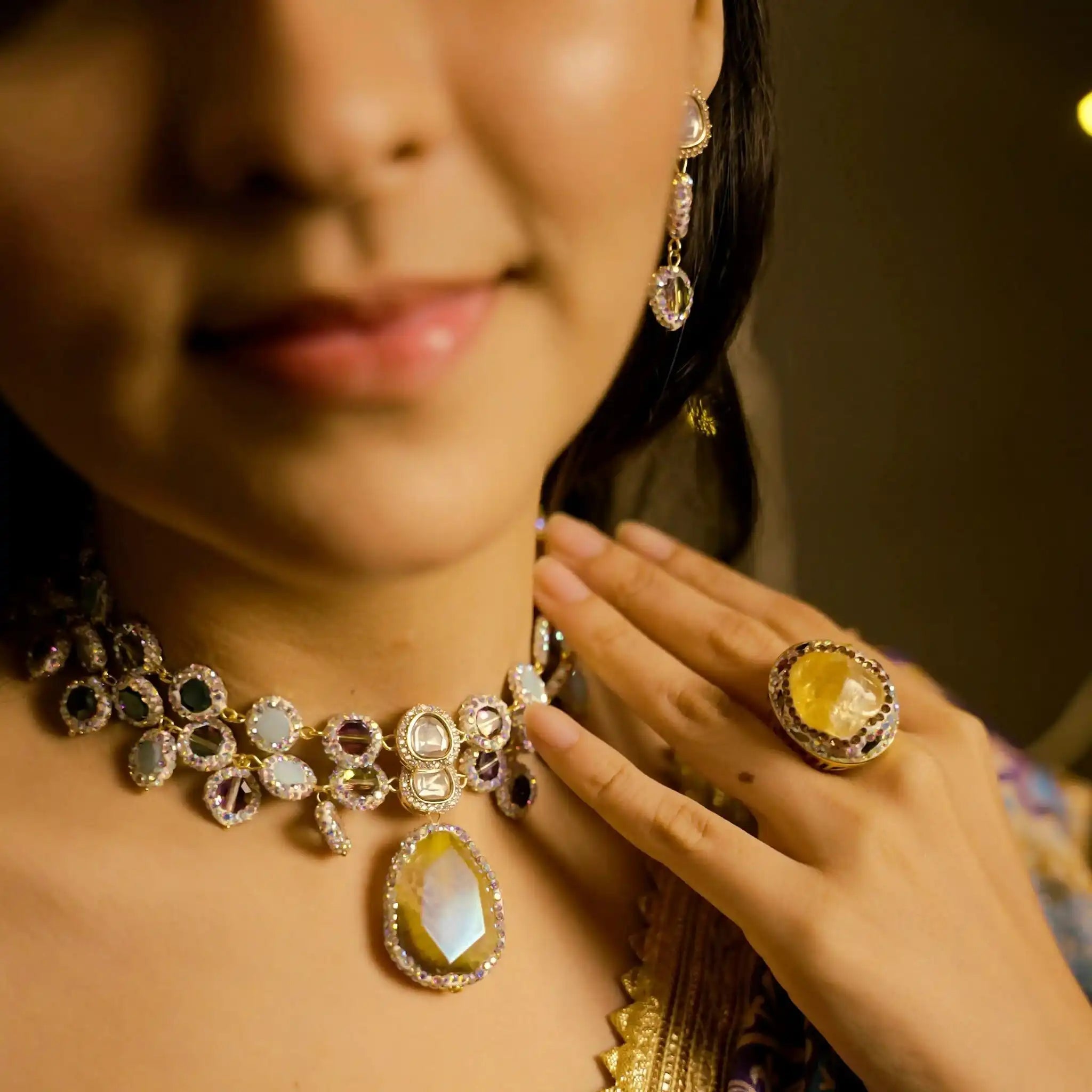Close-up of a person wearing a decorative necklace and ring with a blurred background
