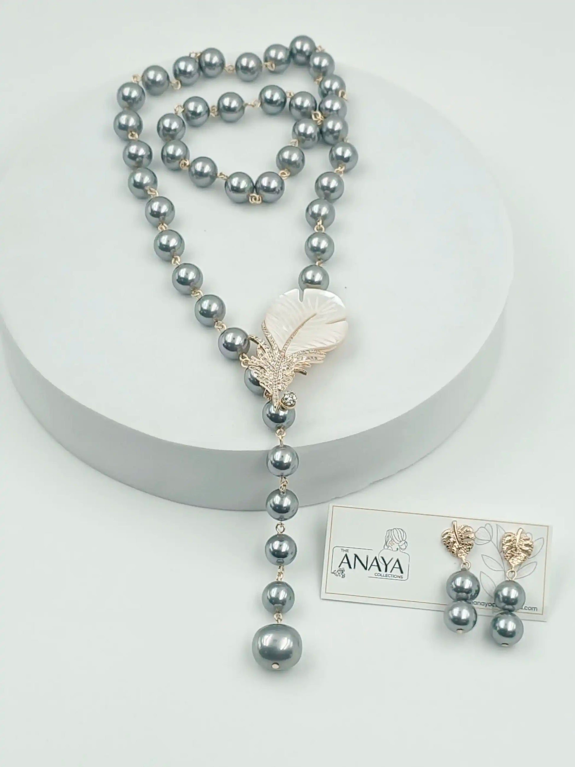 Pearl necklace with a Feather pendant on a white background, featuring The Anaya Collections jewelry.