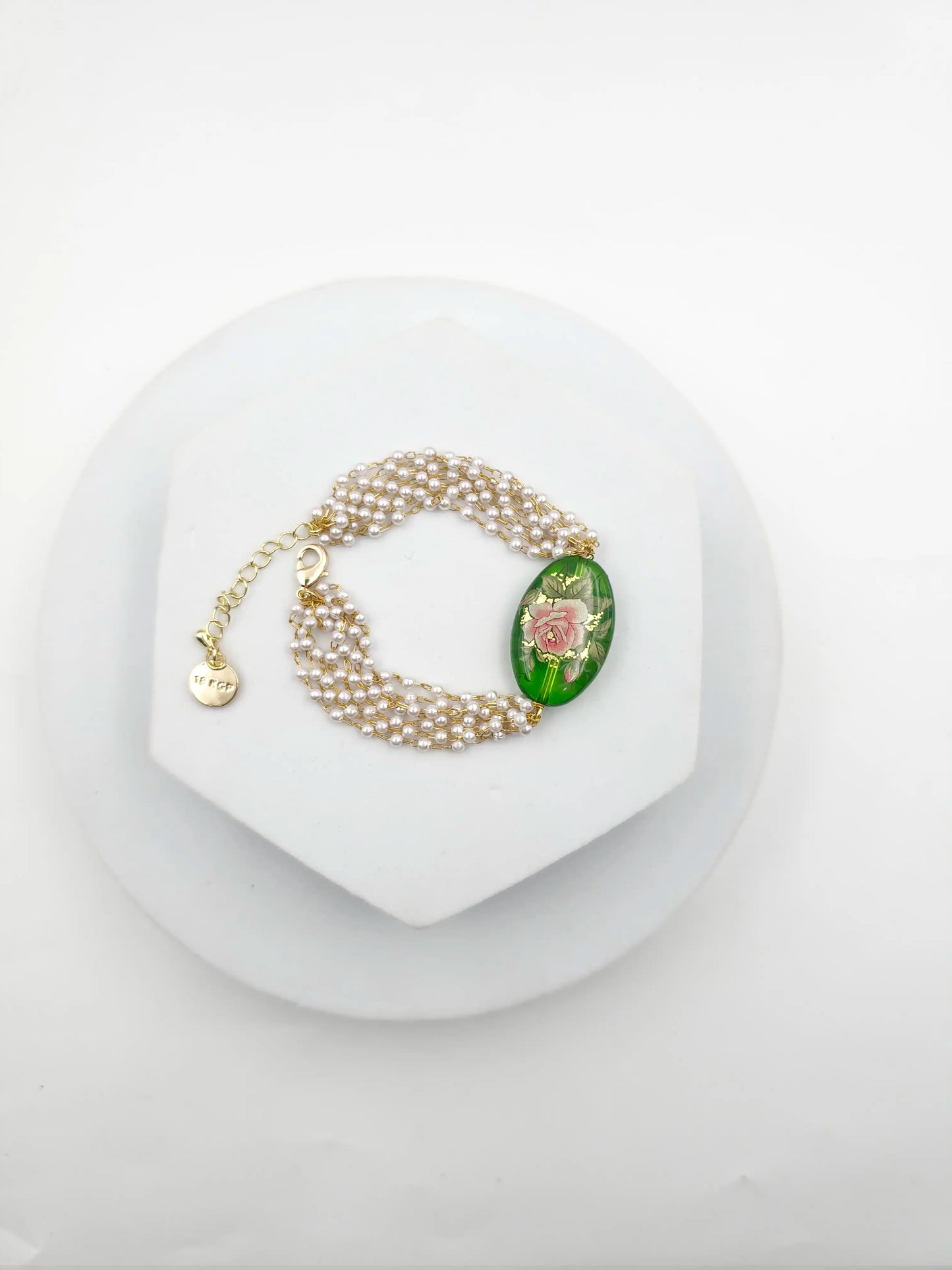 Pearl bracelet with a decorative clasp on a white background