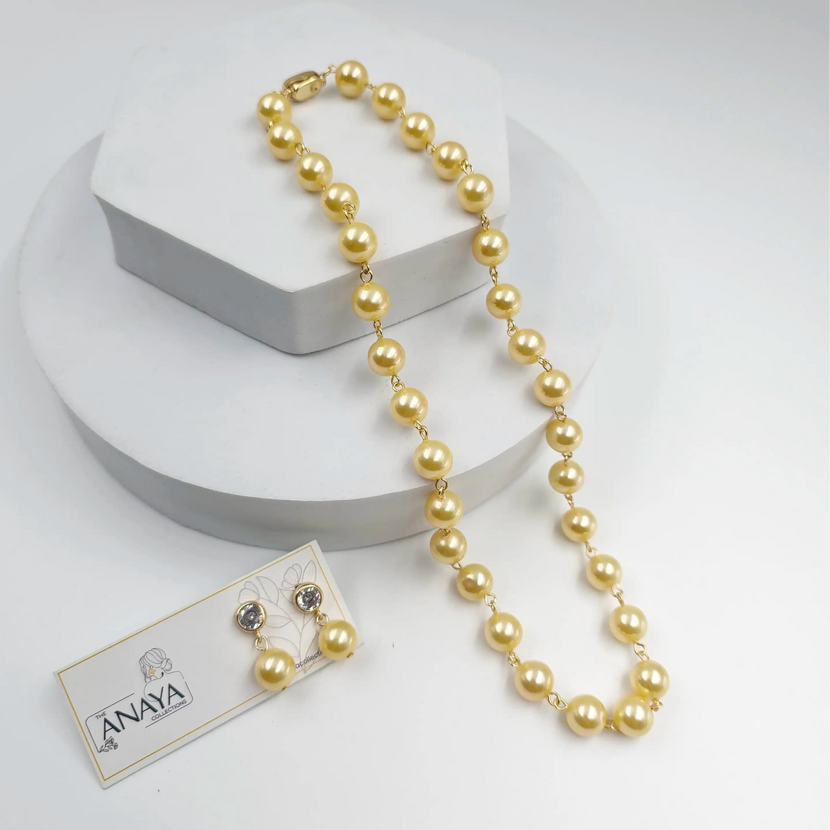 Yellow Pearl necklace with a tag on a white background