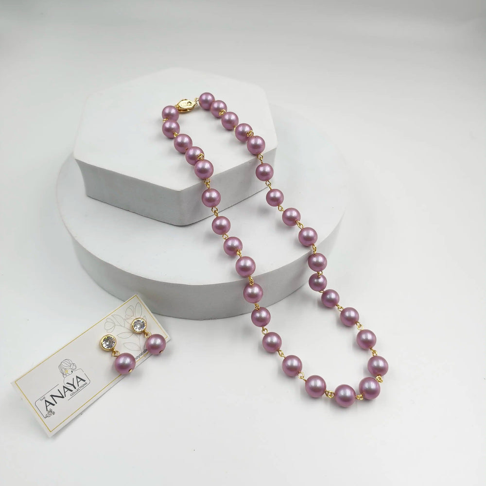 Purple pearl necklace with a tag on a white background